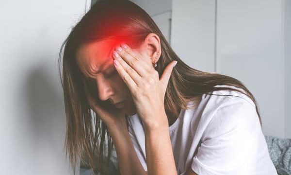 Young,Woman,Touching,Her,Temples,And,Suffering,From,Head,Pain, Young woman touching her temples and suffering from head pain, headache or migraine